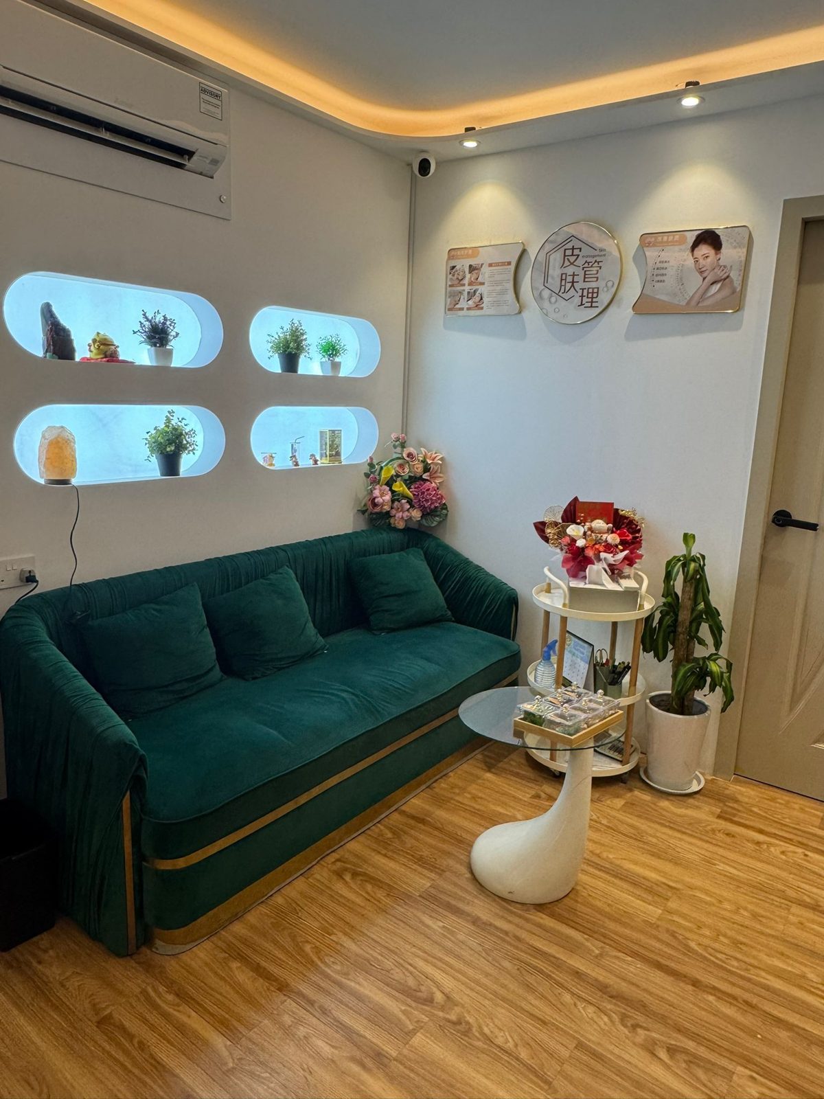 The waiting area with a green velvet sofa and plants